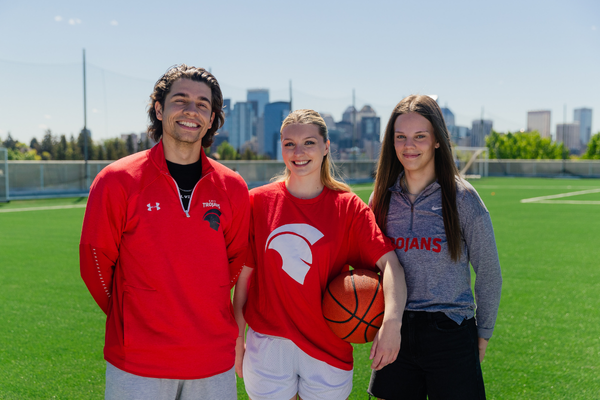 three athletes standing on soccer pitch