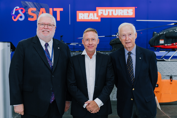 three mature men in suits posing for photo