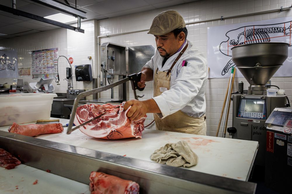 Butcher slicing a cuts of meat.