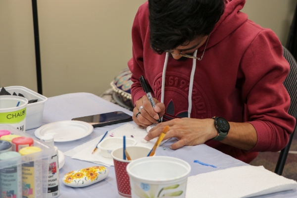 A student paints at a table in the Zen Den.
