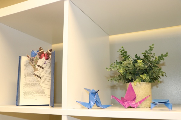 A Zen Den wall shelf displays pink and blue paper cranes.
