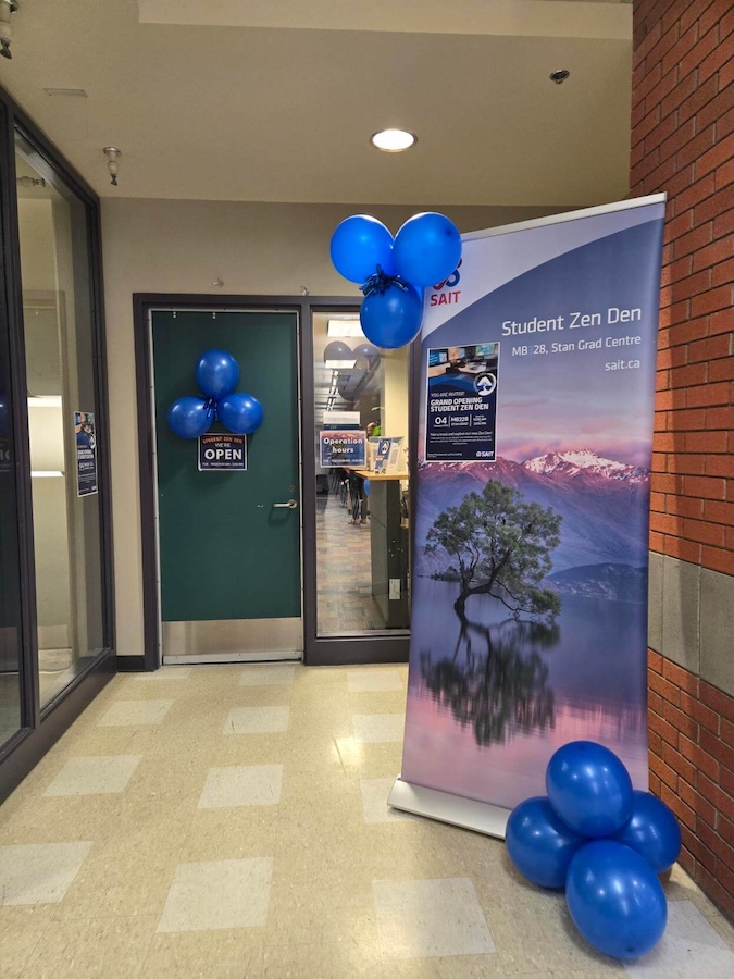 Two students do a craft in the Zen Den, surrounded by art supplies.
