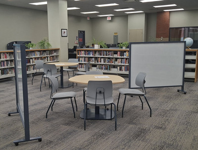 photo of the fiction area of the library with new tables,chairs and whiteboards.