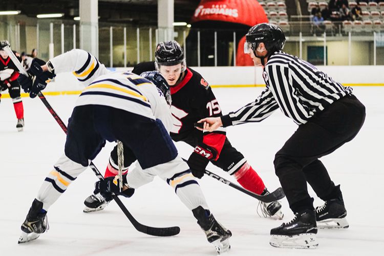 Hockey players face off on the ice.