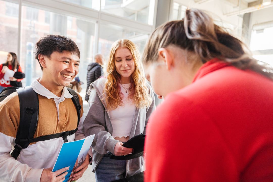 SAIT employee in red talking to students