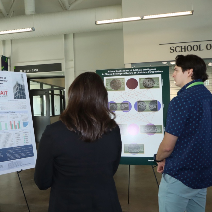 Two students reading research posters.