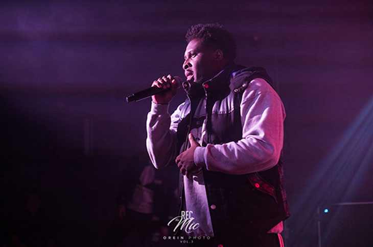Beni Johnson, a black male holding a microphone while on stage talking to audience