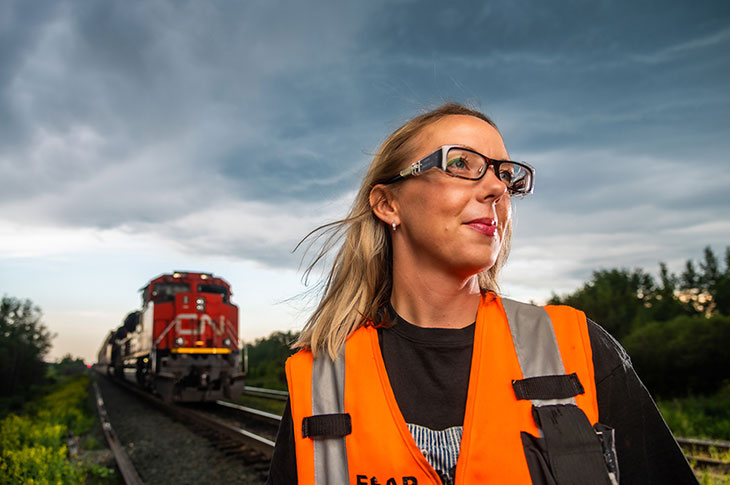 Leslie Lukan with a CN railway engine behind her.