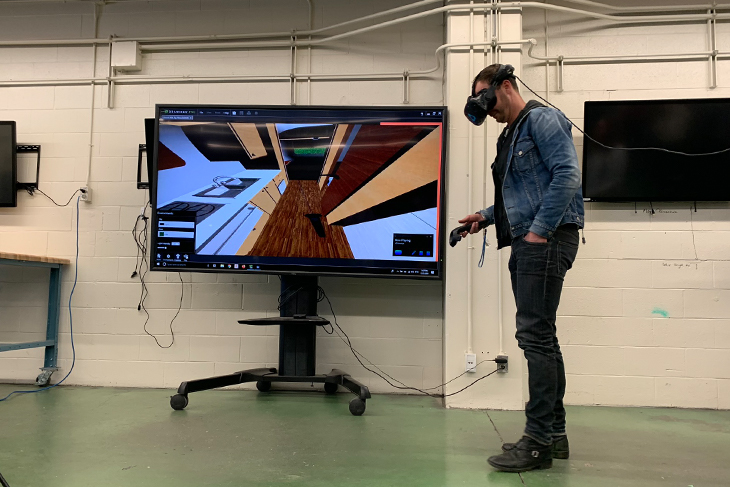 Paul Brandt wearing VR goggles to view one of the student groups' presentation.