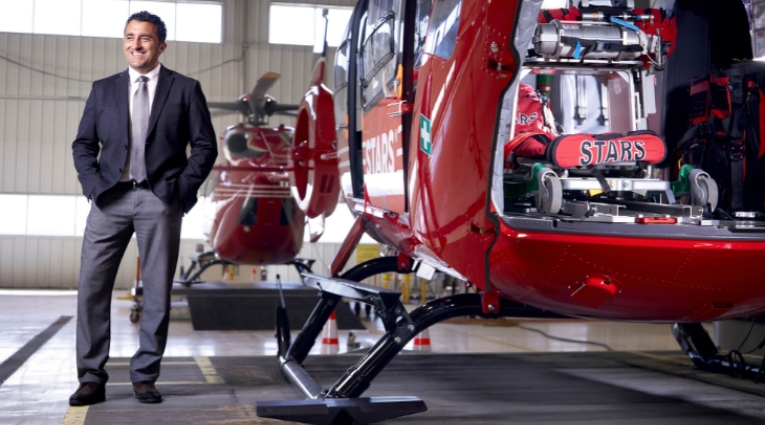Mike Lamacchia stands beside stars helicopter