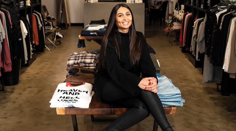A woman sitting in front of shop
