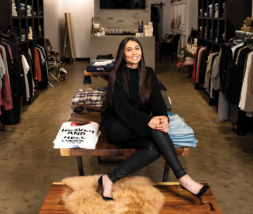 A woman sitting in front of shop