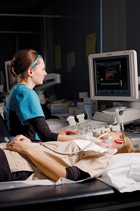 female student practicing ultrasound on female patient