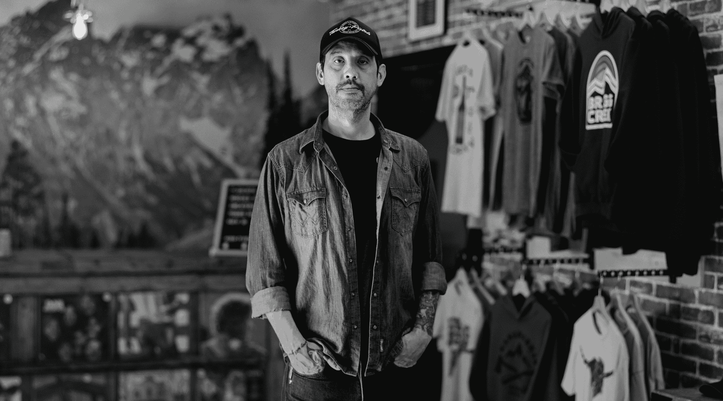 Black and white photo of man standing in store