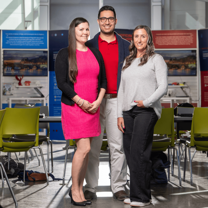 Three people standing in youth learning area