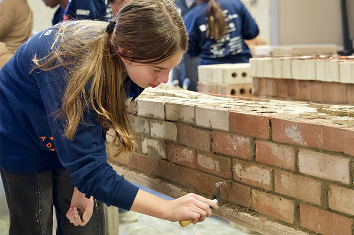 young girl practicing bricklaying