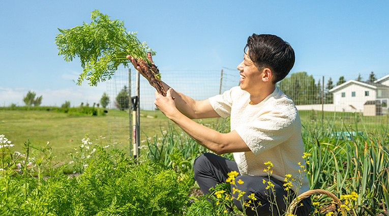 Chef Jun Young Park admires some carrots he just picked from his garden.