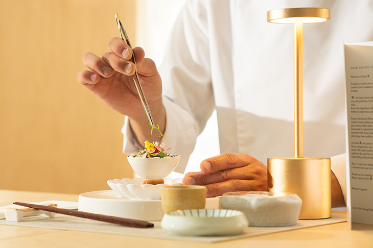 Chef Jun Young Park carefully prepares a dish in his restaurant, Ryuko.