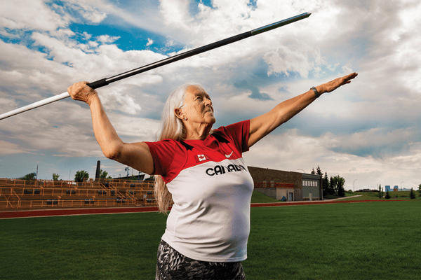 mature woman holding javelin preparing to throw