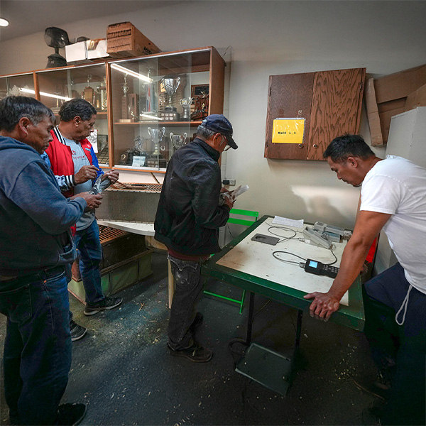 four males in a room holding pigeons