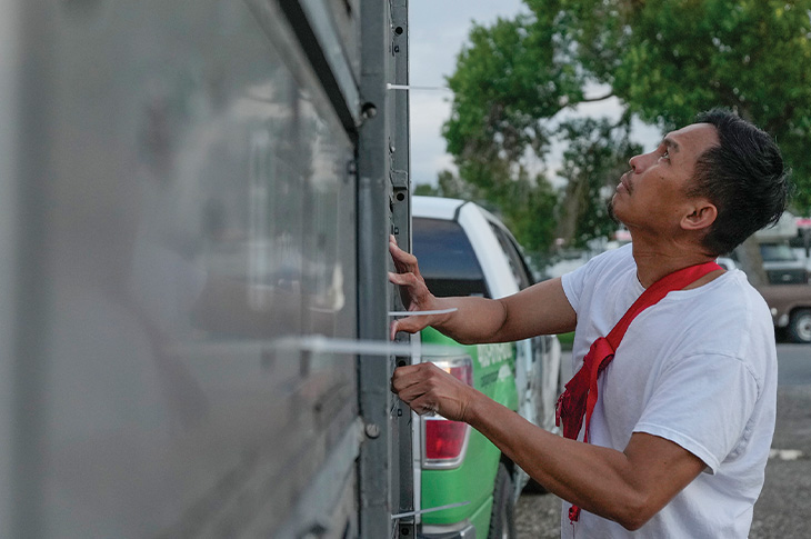 male checks doors of crate are secure and locked