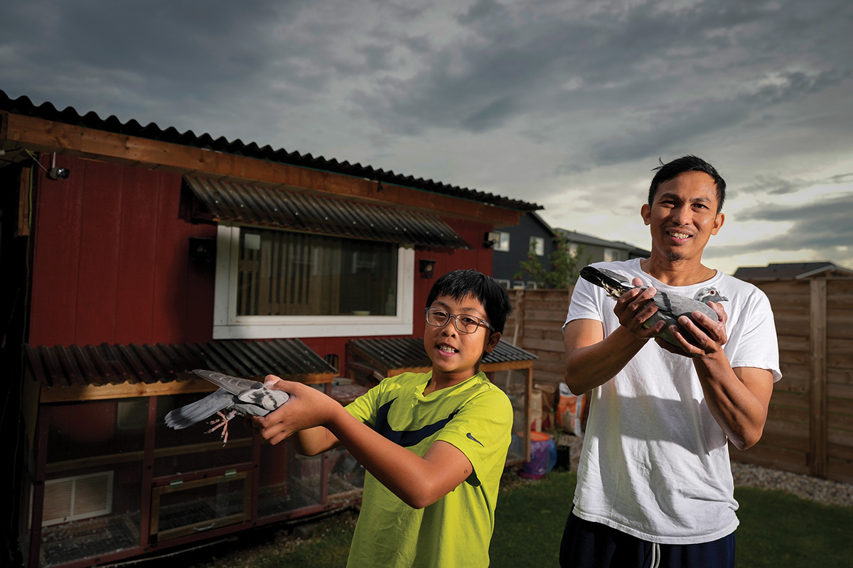 father and son holding pigeons
