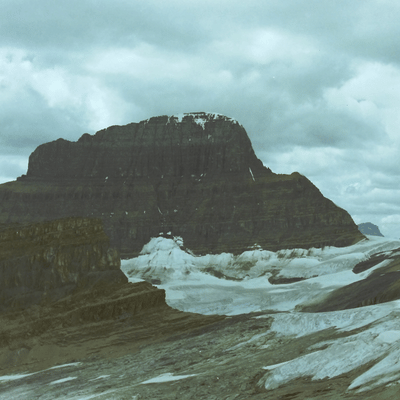 Flat-topped mountain above a glacier under cloudy skies.