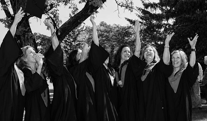 Yearbook photo of graduates in gowns tossing caps in air