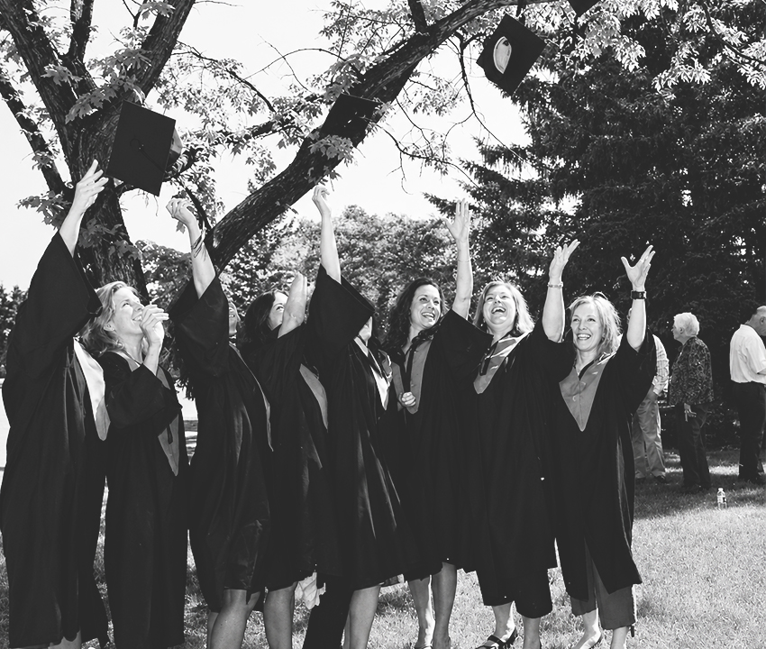Yearbook photo of graduates in gowns tossing caps in air