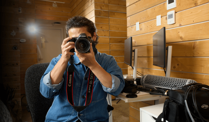 Asian man hold camera smiling