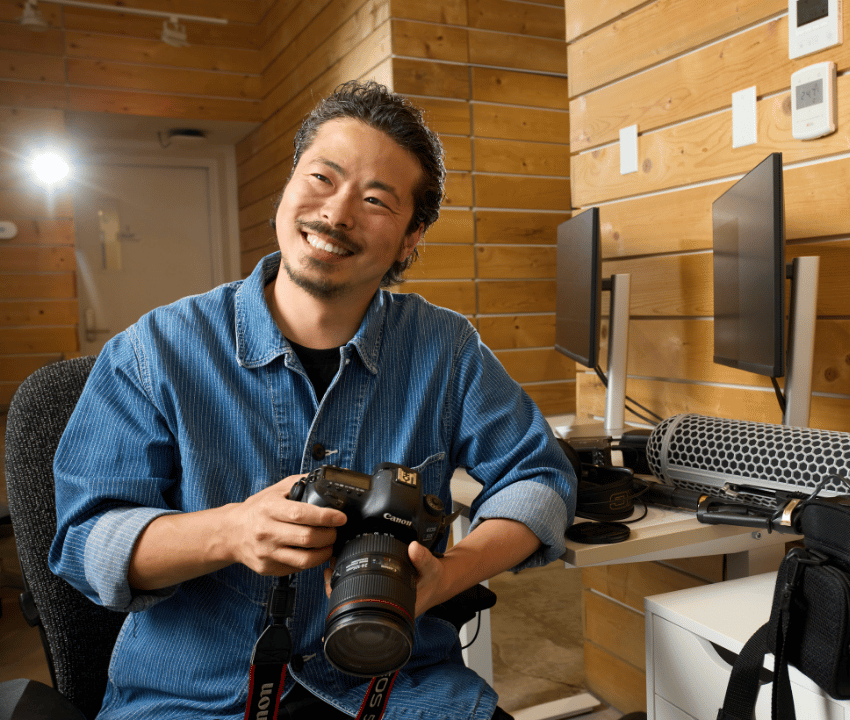 Asian man hold camera smiling