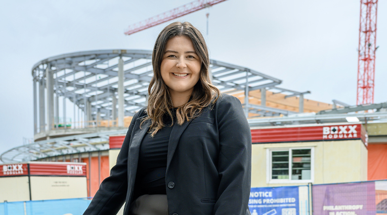 Sophie stands in front of a construction site