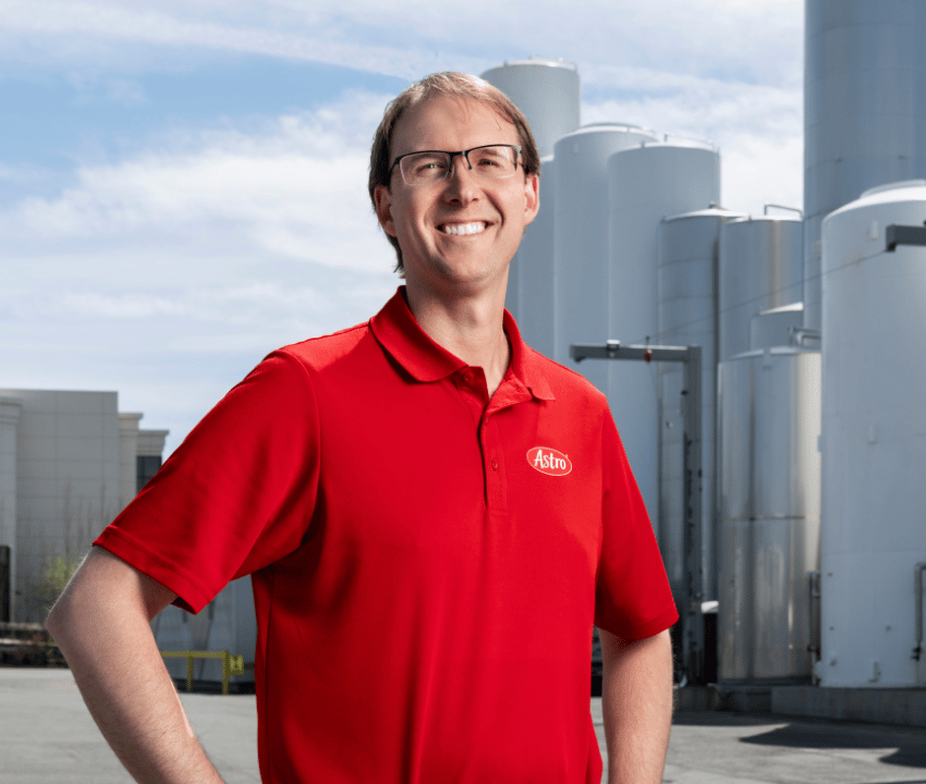 Man standing in work yard in front of silos