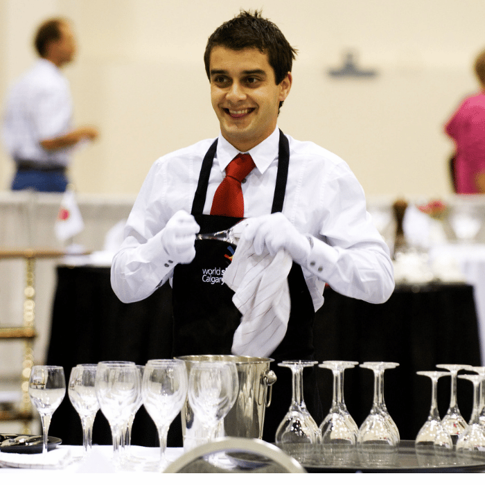 man smiling cleaning glassware