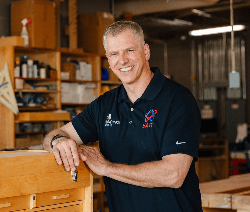 man in dark polo shirt smiling at camera