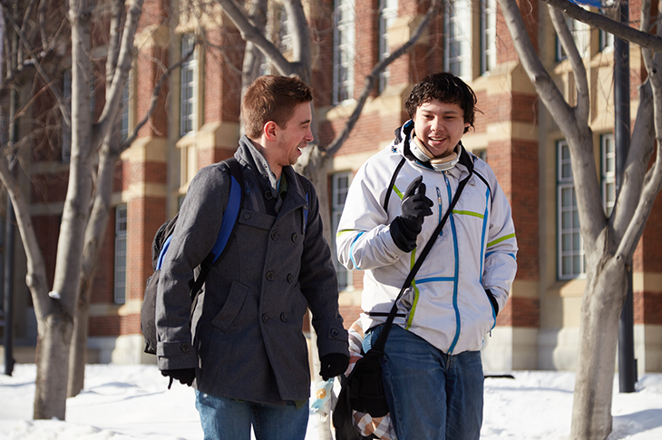 Two students chatting and smiling outdoors