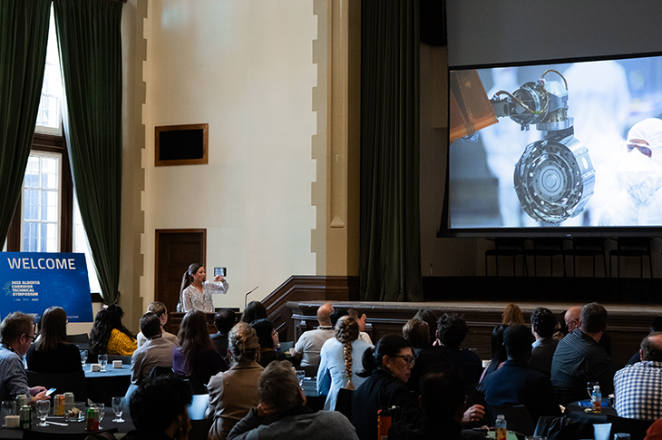 A woman presenting in front of a crowd