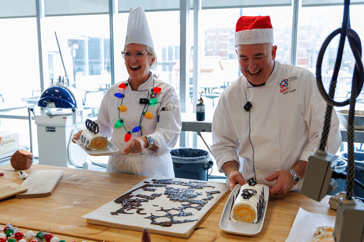 Two chefs making swiss rolls