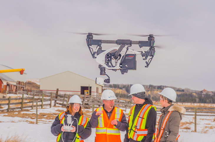 Students piloting drone in a field