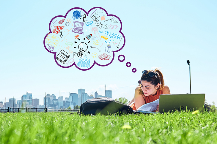 A student lays in the grass with the Calgary downtown skyline in the background. A though bubble graphic with sketches of a laptop, lightbulb, book and other images is shown above the student.