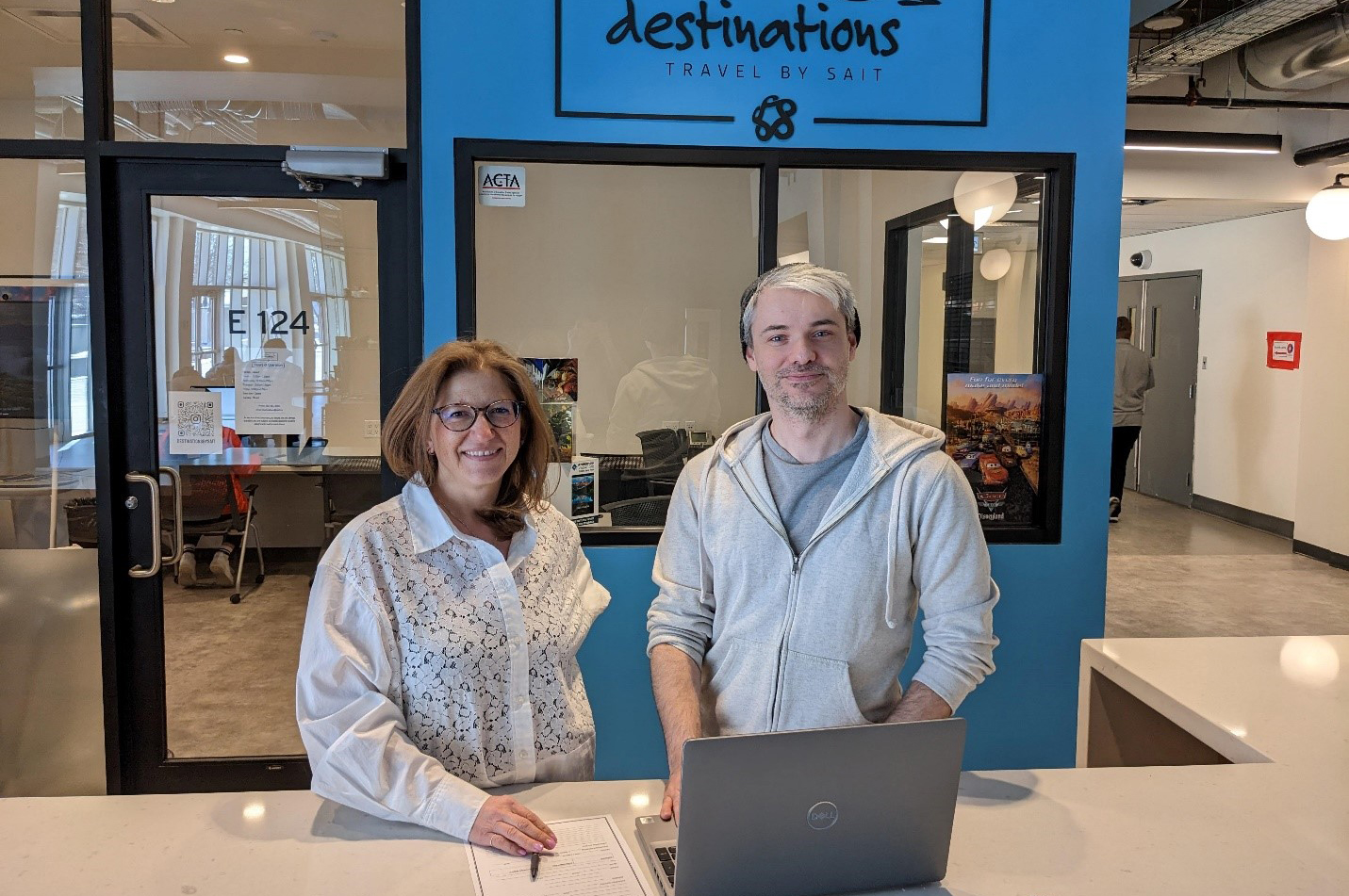 Hospitality and Tourism Management Instructor Stephanie Mercredi and second-year student Jordan Dahl stand outside Destinations Travel by SAIT.