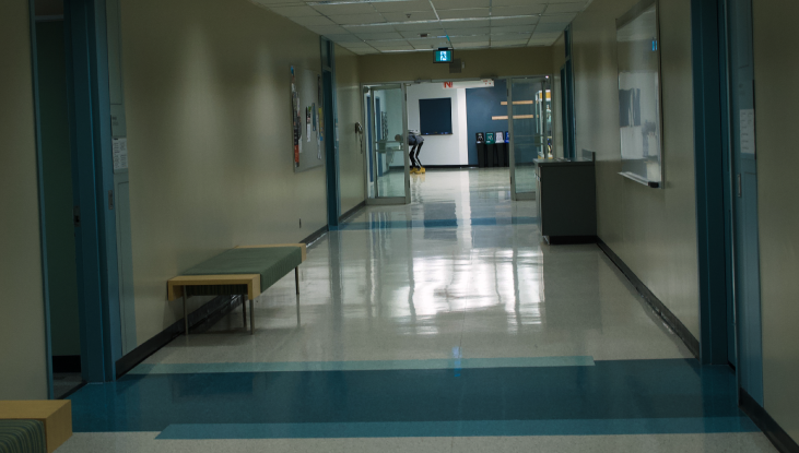 A shot of an empty hallway on SAIT’s campus with white walls and blue accents.