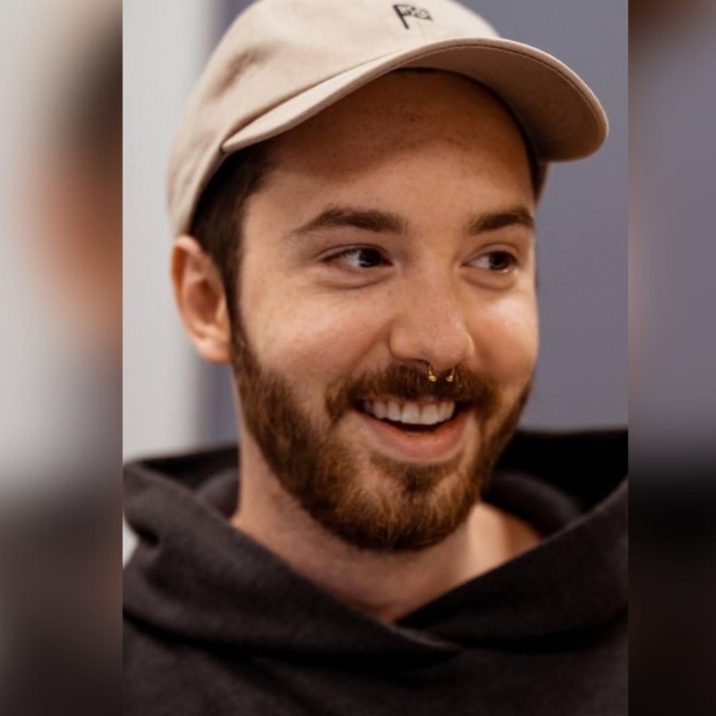 Headshot of Assistant Script Supervisor and SAIT grad Ben Saracini. Ben is wearing a black hoodie and beige ballcap.