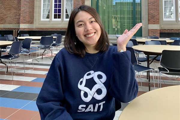 SAIT student Katleah Talusan is smiling in a blue SAIT sweatshirt