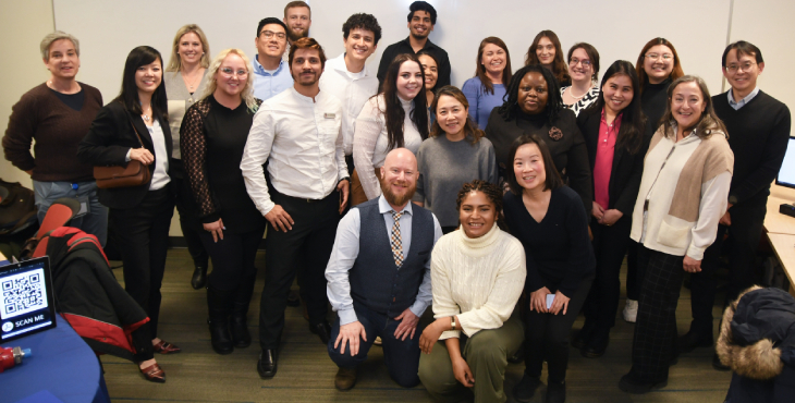 A class of capstone participants look at the camera and smile.