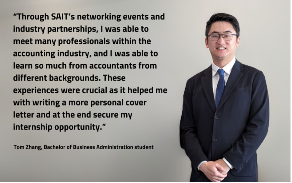 student Tom Zhang standing and smiling in a suit