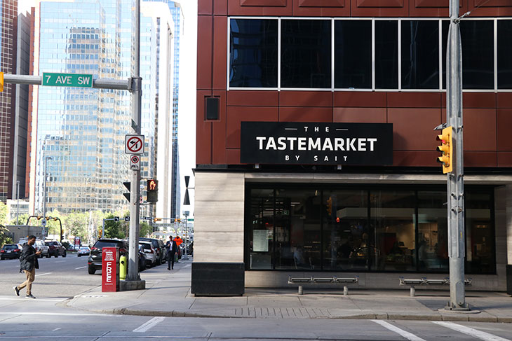 street in downtown Calgary, traffic lights, pedestrian crossing and The Tastemarket by SAIT sign