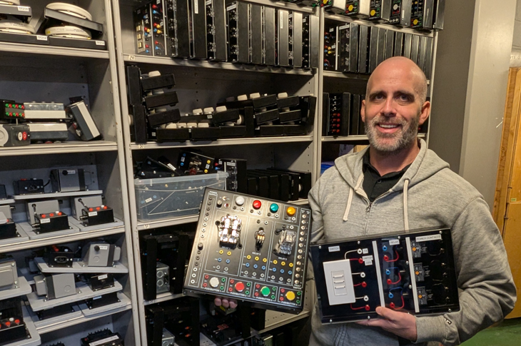 Electrical Instructor David Peard showcases electrical equipment, such as lighting relays, available to students in the lab.