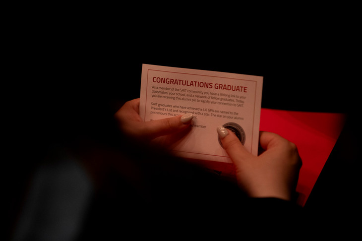 Hands holding a card that reads Congratulations Graduate