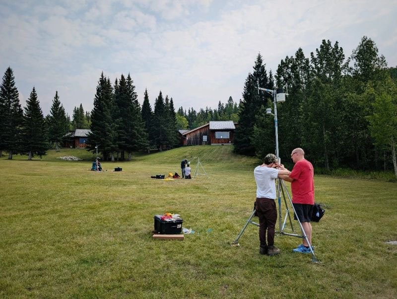 A group of students installing meteorological equipment in a field